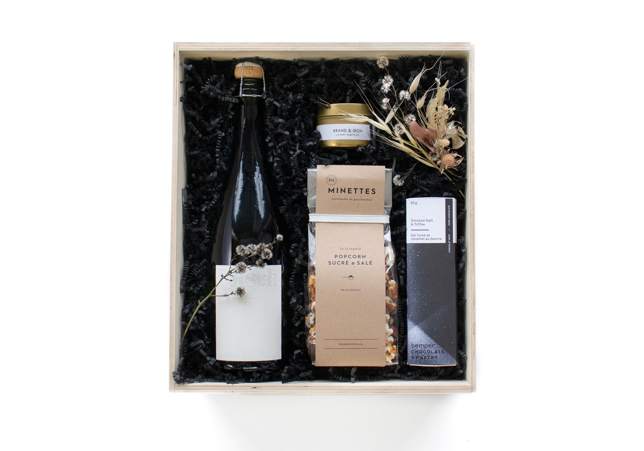ETINCELLE is a decadent gift box that contains BC sparkling wine, Brand and Iron travel tin candle, les minettes sweet and salty popcorn temper chocolate.